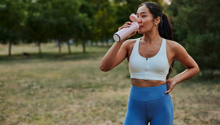 young-woman-drinking-water-while-exercising-at-the-park